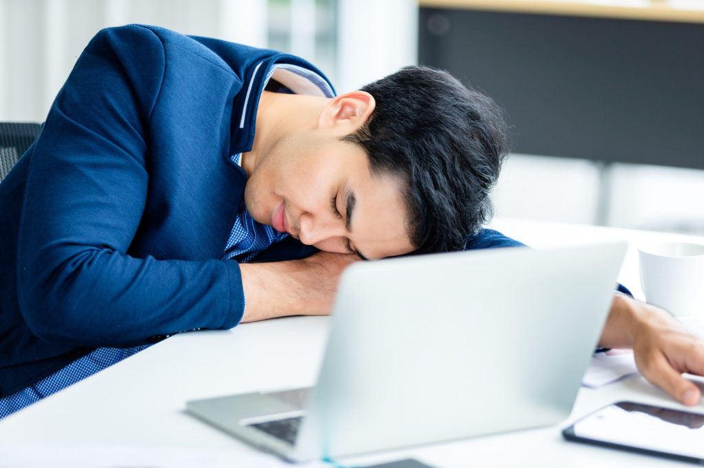 individual suffering executive dysfunction fell asleep on his laptop after exhausting day at office